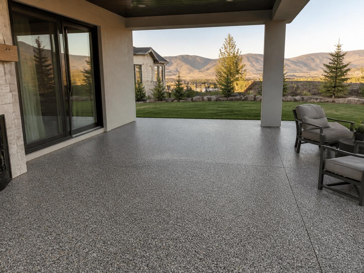 Covered residential patio with a textured gray floor and mountain views